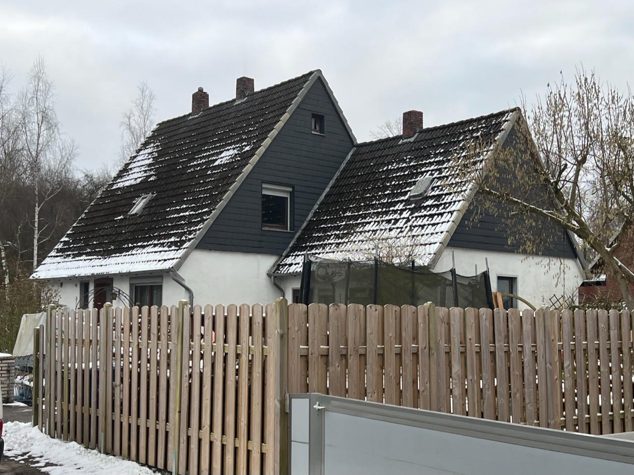 Steildach vor der Sanierung mit Schnee auf alten Dachziegeln